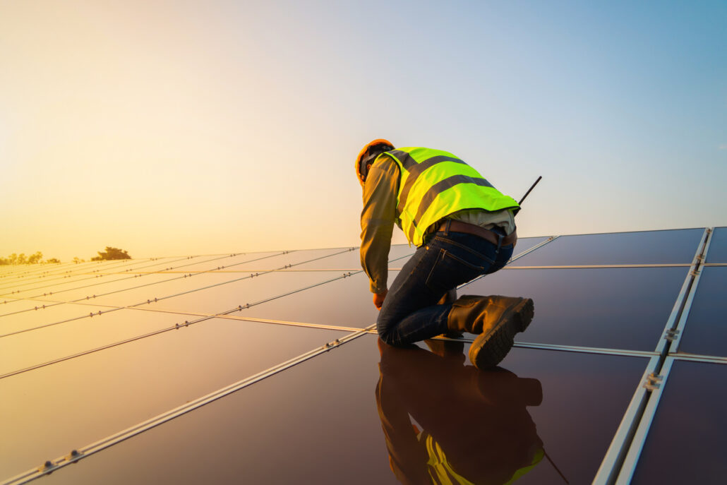 Image of a technician working on panels at a solar farm